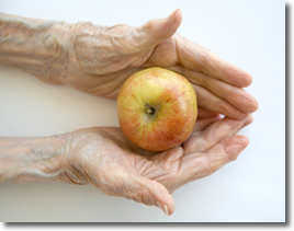 Older hands holding an apple